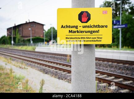 02. August 2020, Brandenburg, Golßen: Ein Schild mit der Aufschrift 'Achtung - unsichtbare Markierungen! Die künstliche DNA führt zum Täter und macht Metalle unverkäuflich" steht in der Nähe der Station neben den Gleisen. Foto: Soeren Sache/dpa-Zentralbild/dpa Stockfoto