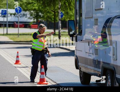 Michendorf, Deutschland. Juli 2020. Ein Polizist kontrolliert während der Verkehrssicherheitskampagne "lieber sicher. Lieber live.' auf dem Gelände der Raststätte Michendorf-Nord. Unter anderem wurde das Gewicht des Fahrzeugs gemessen, das aufgrund von Gepäck und anderer Last zu hoch sein könnte. Quelle: Soeren Stache/dpa-Zentralbild/ZB/dpa/Alamy Live News Stockfoto