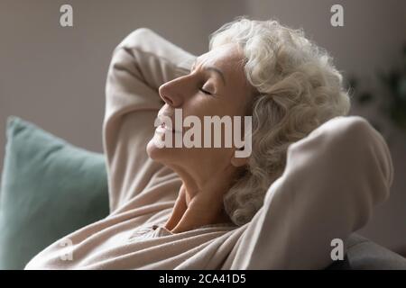 Großmutter legte die Hände hinter den Kopf entspannen auf Couch Nahaufnahme Foto Stockfoto