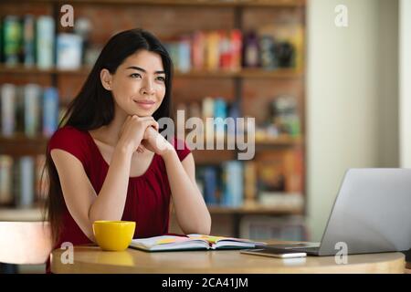 Tagträumen. Portrait von nachdenklichen asiatischen Mädchen Freiberufler sitzen am Café-Tisch Stockfoto