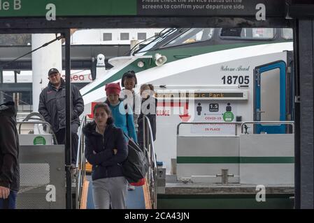 Mit einer Covid-19-Fluggastbeschränkung im Hintergrund steigen die Leute von einer Sydney River Cat Ferry am Circular Quay Terminal in Sydney aus Stockfoto