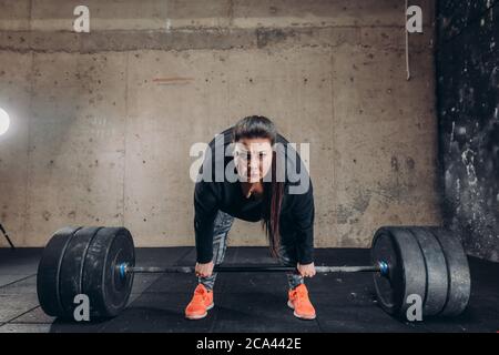 Fat wütend weiblichen Bodybuilder lernen, die Langhantel zu heben. Motivation. Schwierigkeiten beim Abnehmen Stockfoto