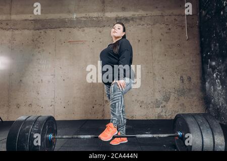 Fat Sportlerin posiert vor der Kamera im Bodybuilding Club. Ganzkörperaufnahme Stockfoto