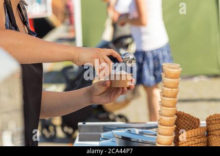 Weibliche Verkäuferin verkauft Eis auf Naplavka Bauern Straße Lebensmittelmarkt in Prag, Tschechische Republik. Stockfoto