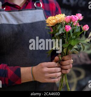 Floristen Mann machen Blumenstrauß im Geschäft Stockfoto