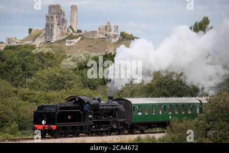 Die Dampflokomotive SR U Class 31806 fährt auf der Swanage Railway zwischen Norden und Swanage an Corfe Castle vorbei. Stockfoto