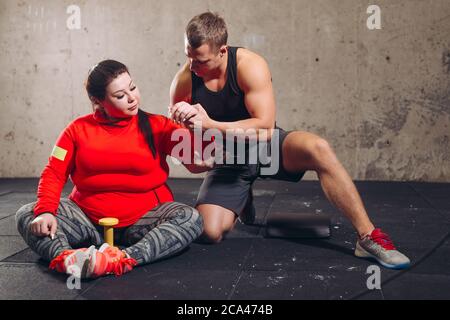 Personal Trainer Korrektur der plump Client-Haltung. Voller Länge Foto. Freizeit, Lebensstil Stockfoto