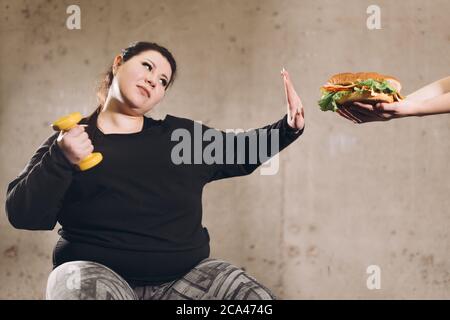 Aufhören zu essen Fast Food, gehen Sie für sport.plump Mädchen rejuces jink Food. Gesundes Leben, Gesundheit und Körperpflege.closeup Foto Stockfoto