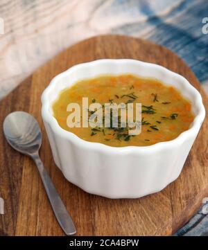 Vegetarische Bohnensuppe mit Karotten und Dill auf einem Holzständer Stockfoto