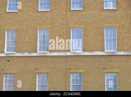 Fenster auf einem viktorianischen Gebäude bilden ein Muster Stockfoto
