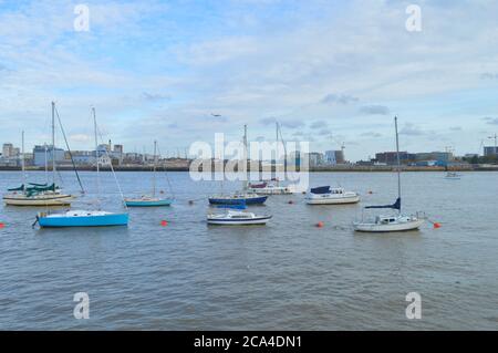 Die Boote liegen auf der Themse und die Skyline von London ist im Hintergrund zu sehen