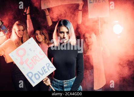 Feminismus-Konzept. Porträt der weiblichen halten Plakat, auf dem Mädchen Macht geschrieben ist, trägt schwarze Bluse und mit kurzen blonden Haaren, stehen isoliert i Stockfoto