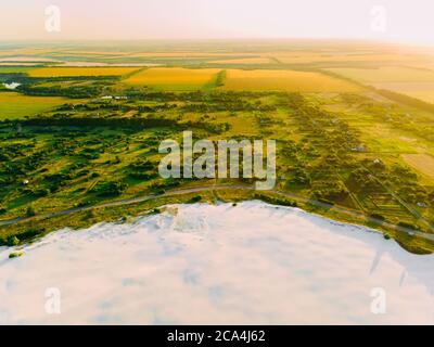 Die Grenze des Wüstengebietes und der grünen Wiese mit dem Fluss ist das Ergebnis der menschlichen zerstörerischen Tätigkeit in der Umwelt. Blick von der Drohne. Stockfoto