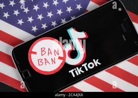 Maski, Indien - 4. August, 2020 : TikTok Logo auf Telefon und Verbotsstempel mit Amerika Flagge Hintergrund. Stockfoto