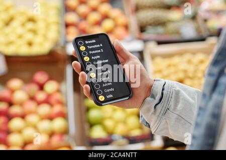 Nahaufnahme von nicht erkennbaren Mann mit Check-Liste App beim Kauf von Lebensmitteln auf dem Bauernmarkt Stockfoto