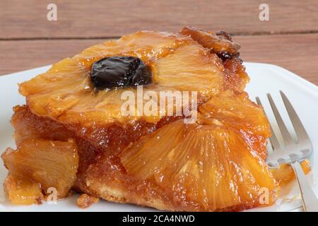 Karamellisierter Ananaskuchen mit Pflaumen. Textur. Nahaufnahme. Ein Stück Kuchen Stockfoto
