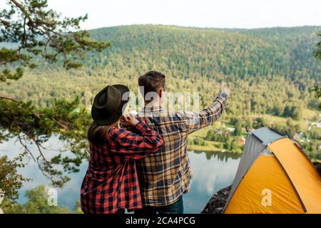 Zwei junge Touristen, die in der Ferne, Mann zeigt auf den erstaunlichen Wald, Rückansicht Foto. Copy space Stockfoto