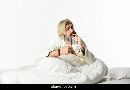 Start Tag mit gutem Kaffee. Gourmet-Espresso. Genießen Sie den morgendlichen Kaffee. Schöner Mann trinkt Kaffee. Reifer bärtiger Mann im Bett. Der Körper wurde von wesentlichen Komponenten für eine gute Gesundheit und Energie beraubt. Stockfoto
