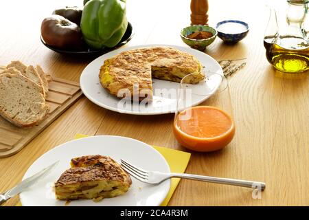 Typisch spanische Küche. Kartoffelomelett und Gazpacho auf einem Tisch serviert mit verschiedenen Zutaten garniert. Stockfoto