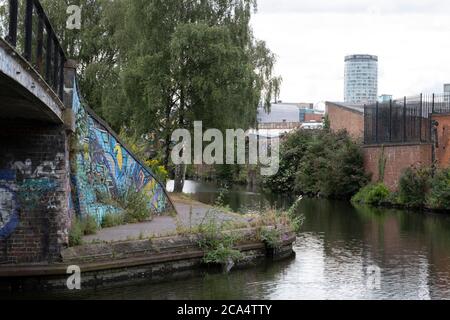 Szene am Ende des Grand Union Canal, auf dem Digbeth Branch Canal ganz in der Nähe des Stadtzentrums, wo alte, zerbröckelnde Gebäude einen Vordergrund zu einer modernen Stadt und dem ikonischen Rotunda Gebäude am 3. August 2020 in Birmingham, Großbritannien. Birmingham hat rund 35 Meilen von Kanälen, angeblich mehr als in Venedig, und sind sehr viel eine Erinnerung an ein Birminghams Industrieerbe. Während der industriellen Revolution waren diese Kanäle beschäftigt, transportierten schwere Güter wie Kohle, Eisen, während sie eine entscheidende Rolle bei der Entwicklung von Birmingham als industrielles Kraftpaket spielten. Stockfoto