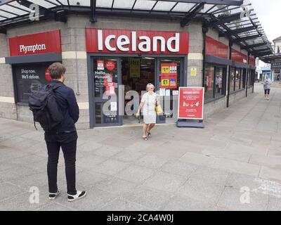 Schlange von Menschen außerhalb zeigen auf Höhe der Beschränkungen warten Zum Kauf von Waren und Einkaufen Covid 19 Coronavirus Soziale Distanzierung Stockfoto