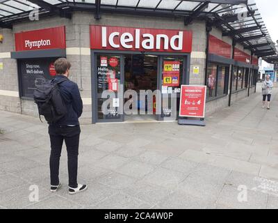 Schlange von Menschen außerhalb zeigen auf Höhe der Beschränkungen warten Zum Kauf von Waren und Einkaufen Covid 19 Coronavirus Soziale Distanzierung Stockfoto
