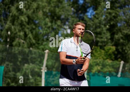 Rückkehrer schlagen Ball auf dem Tennisplatz, damit glückliche Sportler Pausen dienen von seinem Gegner Stockfoto