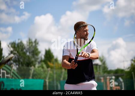 Bestimmt blond männlichen Tennisspieler ist bereit, wieder eine starke dienen, von einem Trainer ein zu gewinnen motiviert werden. Stockfoto