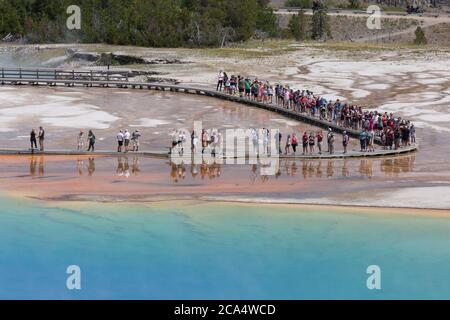 Besucher spazieren am Montag, 3. August 2020, entlang der Promenade des Grand Prismatic Spring. Viele der Parks Promenade wurden in eine Richtung gemacht, um die Übertragung des COVID-19-Virus zu bekämpfen. Der Park berichtete vor kurzem über mehrere positive Fälle des COVID-19 Virus bei Besuchern und Konzessionärinnen. Stockfoto