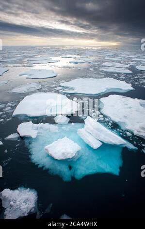 Meereisschollen in der Nordarktik mit Unterseite sichtbar durch Oberfläche gebrochen durch globale Erwärmung.von oben betrachtet.dramatische grauen Himmel am Horizont Stockfoto