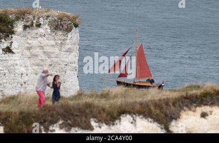 Ein Segelboot macht sich auf der Isle of Purbeck in Dorset an Old Harry Rocks vorbei. Stockfoto