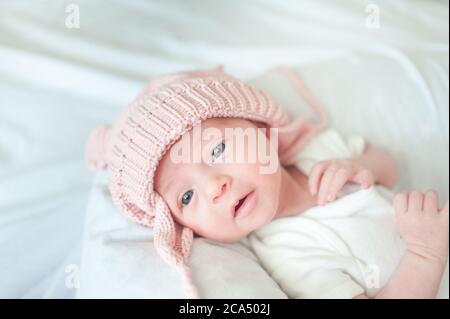 Neugeborenes Baby liegt auf dem Bett mit Hut Stockfoto