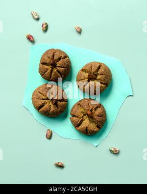 Traditionelle hausgemachte marokkanische festliche Ghoriba Cookies mit Pistazien Nüsse auf trendigen minzfarbenen Hintergrund. Stockfoto