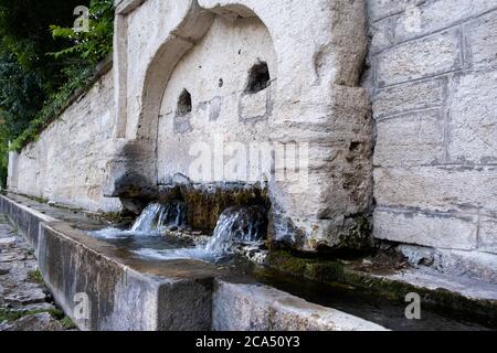 Nahaufnahme des Steintrinkbrunnens mit Wasser aus dem Mittelalter Stockfoto