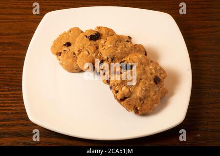 HAFER, CRANBERRY, WEISSE SCHOKOLADE KEKSE IN EINEM WEISSEN TELLER Stockfoto