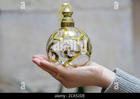 Nahaufnahme der Frau Hand zeigt eine goldene weihnachtskugel Stockfoto