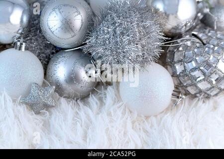 Poster mit silbernen Weihnachtskugeln. Schöne Weihnachtskomposition mit Kopieplatz auf einem flauschigen weißen Pelzhintergrund. Stockfoto