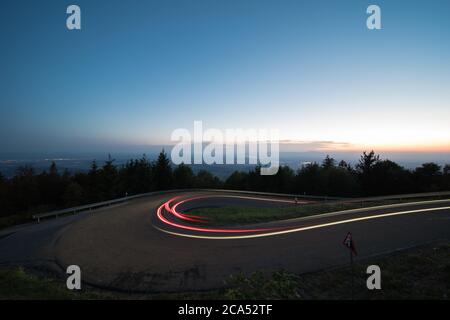 Leichte Wege am Abend von Autos in einer Kurve in deutschland. Stockfoto