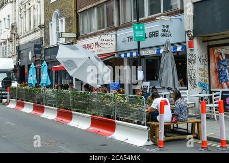 London, Großbritannien. August 2020. Die Gäste können im Freien in einem Pizza- und Griechischen Restaurant in der Berwick Street in Soho essen. Die Restaurants nehmen an dem "Eat Out to Help Out Scheme" der britischen Regierung Teil. Diners erhalten einen Rabatt von 50% (bis zu £10) auf Speisen oder alkoholfreie Getränke zum Essen oder Trinken in, jeden Montag, Dienstag und Mittwoch zwischen 3. Und 31. August. Das Programm zielt darauf ab, die Einnahmen der Hotellerie zu steigern, die während der laufenden Coronavirus-Pandemie schwer getroffen wurde. Kredit: Stephen Chung / Alamy Live Nachrichten Stockfoto