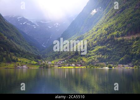Norwegen Landschaft - Hardanger Fiord mit Sonnenstrahlen. Bauernhöfe in der Gemeinde Odda. Stockfoto
