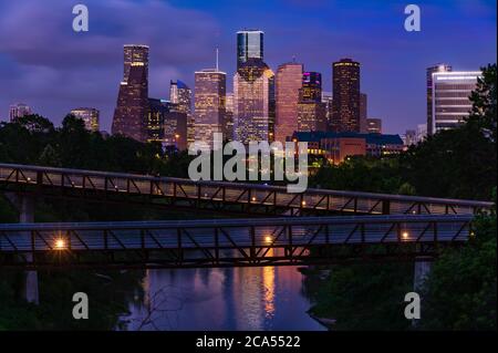 Erhöhter Gehweg über Buffalo Bayou bei Nacht mit Downtown Skyline im Hintergrund, Houston, Texas, USA Stockfoto