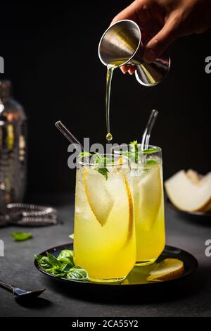 Melonensaft, Limonade in Gläsern mit Eis und Melonenscheiben garniert mit Basilikumblättern. Konzept des frischen Sommergetränks Stockfoto