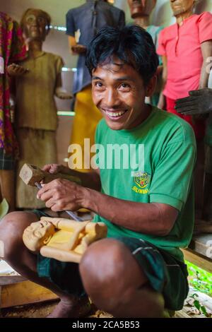 Indonesien, Sulawesi, Tana Toraja, Lemo, Mann, der ein hölzernes Bildnis, genannt Tau-Tau, geschnitzt hat, das eine verstorbene Person darstellt Stockfoto