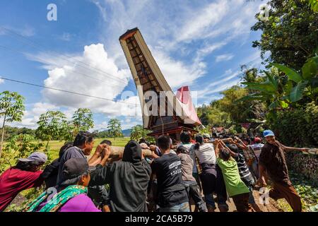 Indonesien, Sulawesi, Tana Toraja, Bori, Trauerfeier, Prozession und Menschenmenge, die den Leichenwagen in Form eines traditionellen Hauses tragen Stockfoto