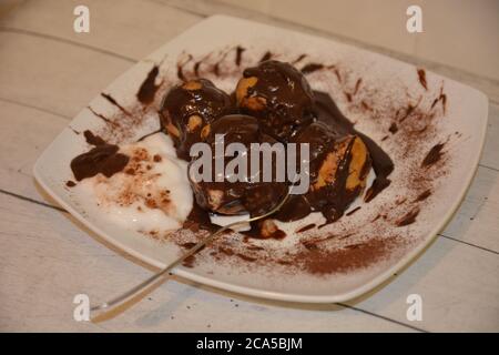 Süße Profitterolkuchen mit Schokoladencreme und Kakao Stockfoto