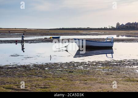 Cristina Island, Huelva, Andalusien, Spanien - Februar 2019: Blick auf den Strand von La Gaviota bei Ebbe, wo einige Fischer Meeresfrüchte abholen. Stockfoto