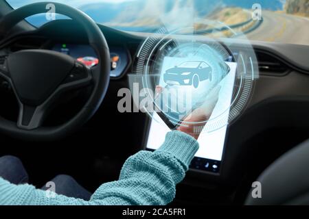 Der Fahrer steuert ein autonomes Auto über ein Smartphone Stockfoto