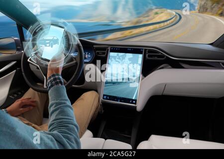 Der Fahrer steuert ein autonomes Auto über ein Smartphone Stockfoto