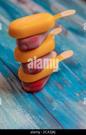 Stapel von Obst-Eis-Stick sieht frisch zu essen auf einem blauen vintage Holzhintergrund platziert. Stockfoto