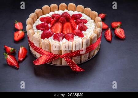 Hausgemachte Erdbeer Tiramisu Kuchen auf schwarzem Hintergrund. Konzentrieren Sie sich auf Erdbeeren. Stockfoto